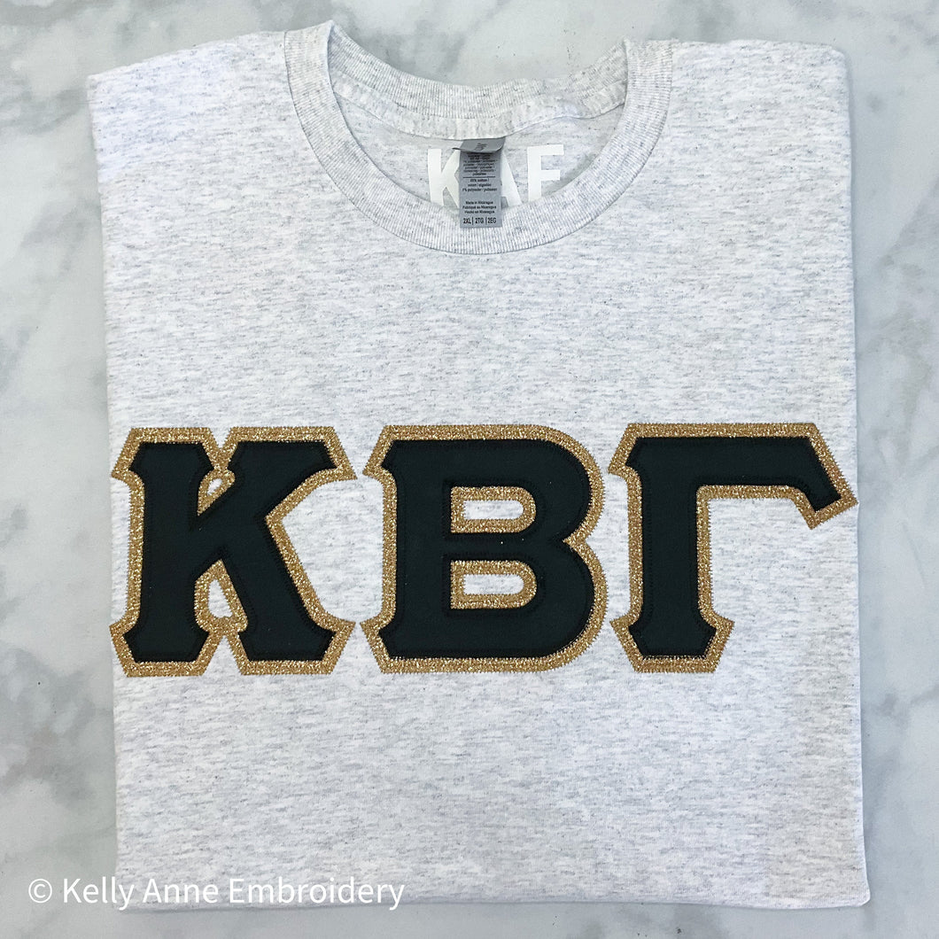 Black Greek Letters with Gold Gliter Border on Ash T-Shirt
